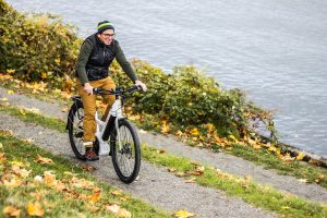 A Man Riding an Electric Bicycle by the River
